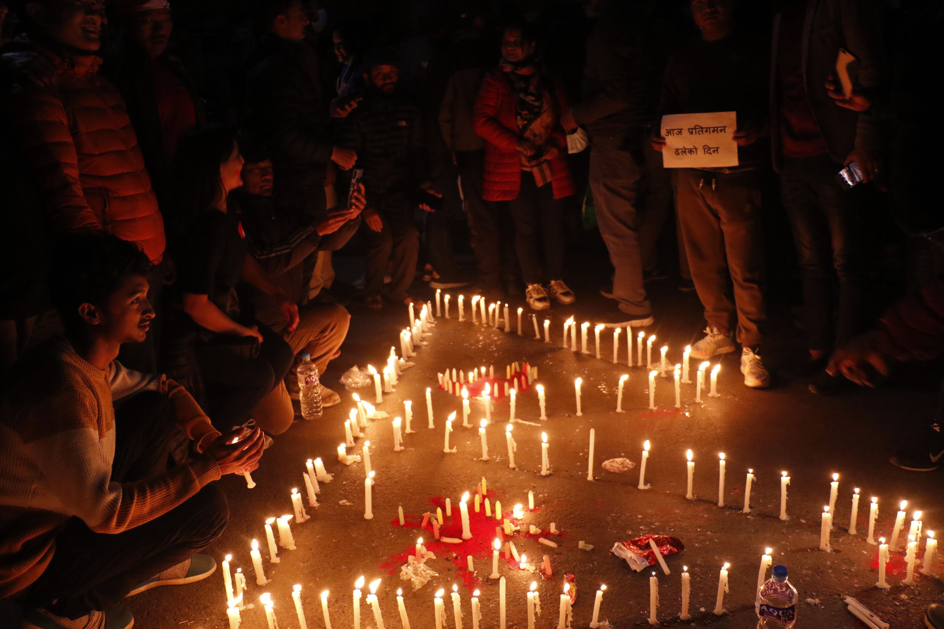 Jubilant people light candles at Maitighar